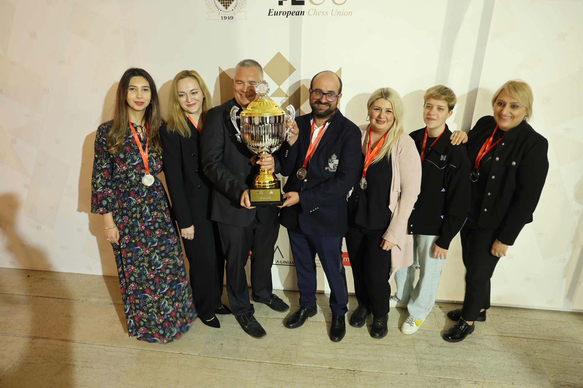 Gambit Bonnevoie with the silver trophy at the event backdrop.