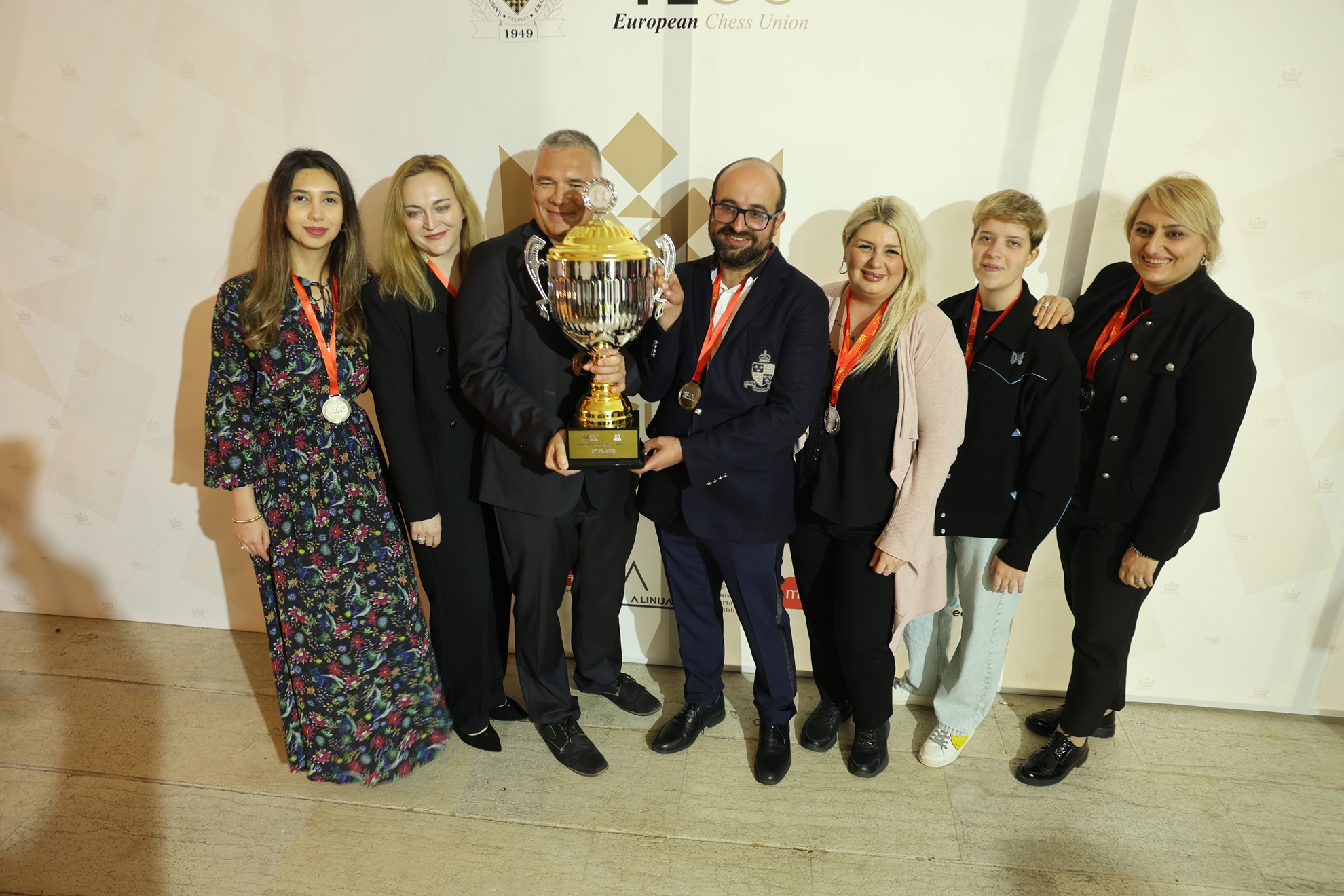 A second group photograph with Gambit’s silver trophy.